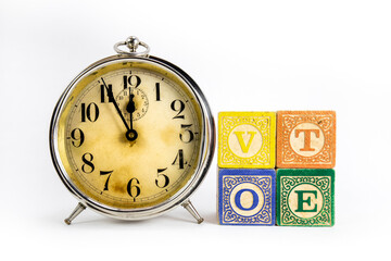 Old Alarm Clock with Wooden Blocks Spell Vote
