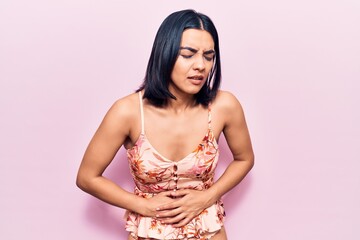 Young beautiful latin woman wearing casual clothes with hand on stomach because nausea, painful disease feeling unwell. ache concept.