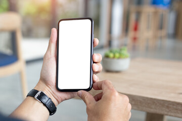 cell phone mockup blank white screen.man hand holding texting using mobile on desk at coffee shop.background empty space for advertise.work people contact marketing business,technology