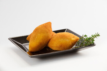 RISOLES EM PRATO PRETO E FUNDO BRANCO