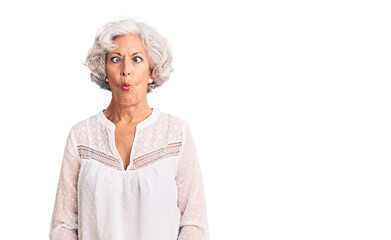 Senior grey-haired woman wearing casual clothes making fish face with lips, crazy and comical gesture. funny expression.