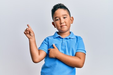 Little boy hispanic kid wearing casual clothes smiling happy pointing with hand and finger to the side