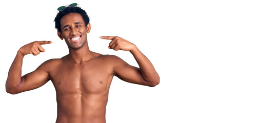 Fototapeta na wymiar African handsome man wearing swimsuit and sunglasses smiling cheerful showing and pointing with fingers teeth and mouth. dental health concept.
