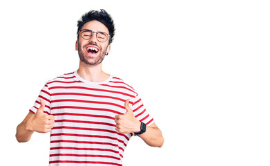 Young hispanic man wearing casual clothes success sign doing positive gesture with hand, thumbs up smiling and happy. cheerful expression and winner gesture.