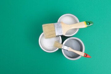 Open paint enamel cans on color palette samples. The concept of repair, construction. Shades of turquoise green.