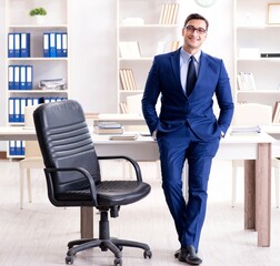 Young handsome businessman employee working in office at desk