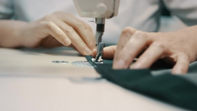 Woman seamstress works at a sewing machine