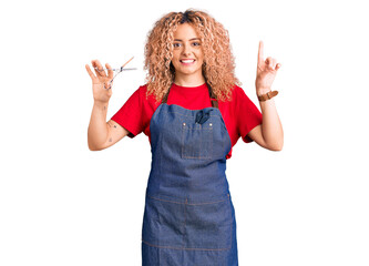 Young blonde woman with curly hair wearing barber apron surprised with an idea or question pointing finger with happy face, number one