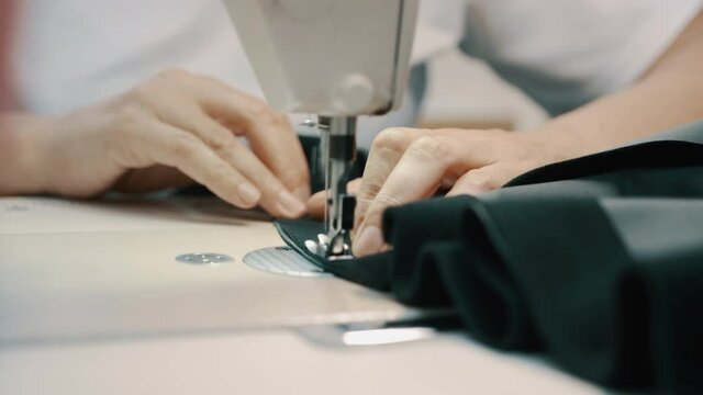 Woman seamstress works at a sewing machine