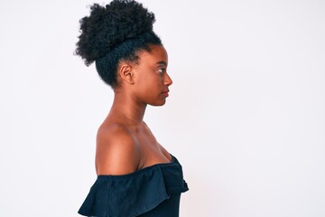 Young african american woman wearing casual clothes looking to side, relax profile pose with natural face with confident smile.