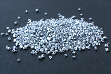 pile of small silver pieces on dark background