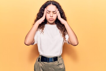 Beautiful kid girl with curly hair wearing casual clothes suffering from headache desperate and stressed because pain and migraine. hands on head.