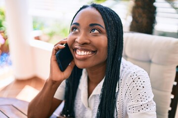 Young african american woman smiling happy using smartphone at terrace
