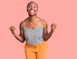 Young african american woman wearing casual clothes very happy and excited doing winner gesture with arms raised, smiling and screaming for success. celebration concept.