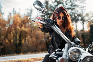 Fototapeta na wymiar Closeup portrait, amazing attractive girl in leather jacket on vintage motorcylce
