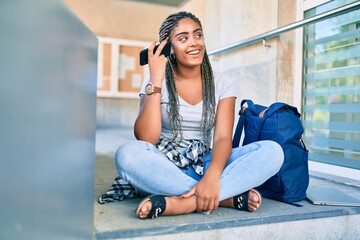 Young african american student woman smiling happy listening to voice message at the university campus