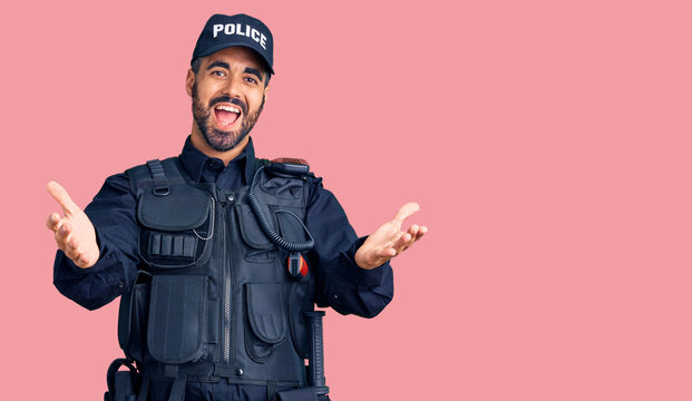 Young hispanic man wearing police uniform smiling cheerful offering hands giving assistance and acceptance.