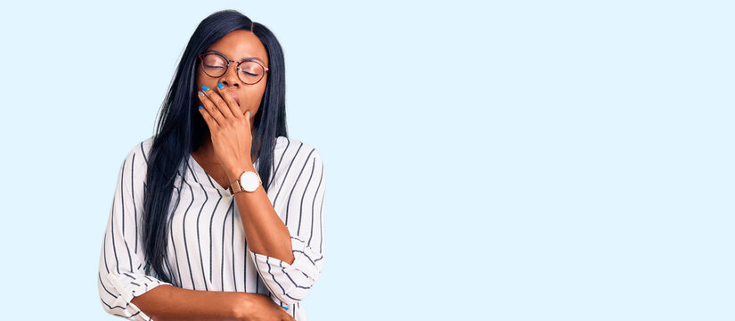 Young african american woman wearing casual clothes and glasses bored yawning tired covering mouth with hand. restless and sleepiness.