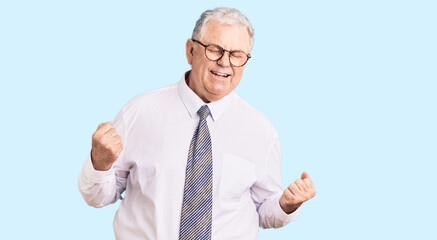 Senior grey-haired man wearing business clothes excited for success with arms raised and eyes closed celebrating victory smiling. winner concept.