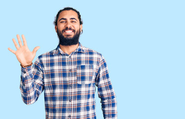 Naklejka premium Young arab man wearing casual clothes showing and pointing up with fingers number five while smiling confident and happy.