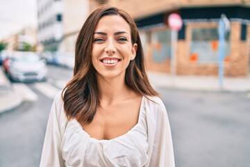 Young hispanic woman smiling happy walking at the city.