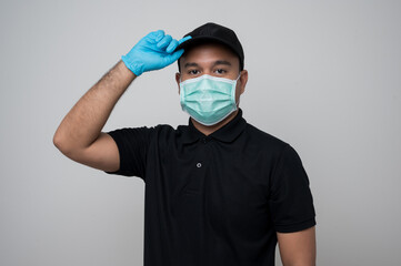 Black uniform delivery asian man wearing protection mask and medical rubber gloves standing on isolated white background safety deliver concept.