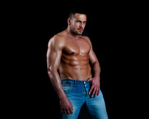 Fototapeta premium Sexy man with muscular body and bare torso on black.