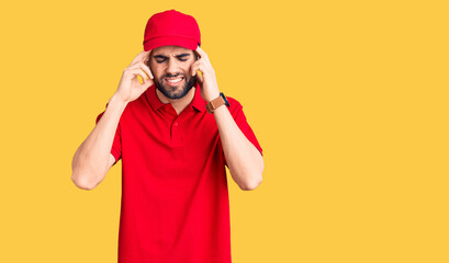 Young handsome man with beard wearing delivery uniform with hand on head, headache because stress. suffering migraine.