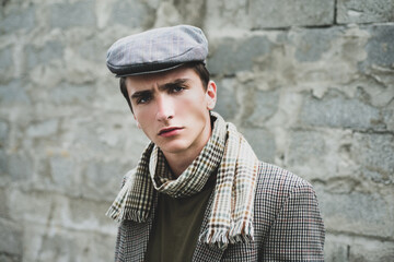 Stylish young man against a grey wall. Retro and vintage old style.