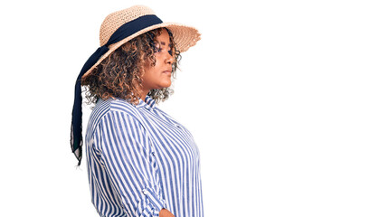Young african american plus size woman wearing summer hat looking to side, relax profile pose with natural face with confident smile.