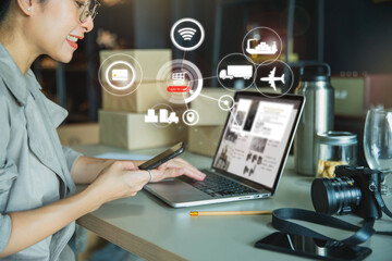 Young business woman working online e-commerce shopping at her shop. Young woman seller prepare parcel box of product for deliver to customer. Online selling, e-commerce.