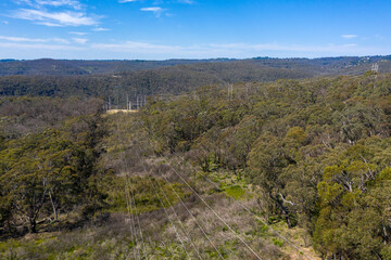 Aerial view of power lines running through a forest in regional Australia