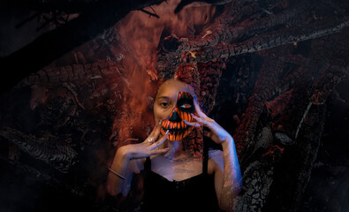 Halloween. portrait of woman with scary mask. Day of the dead, fire background