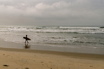 Fototapeta na wymiar surfer walking on the beach