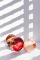 peaches on white wood with light from window with white background