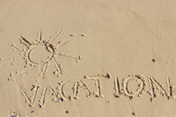 Word vacation and shape of sun written on sand at beach. Summer time. Place for text or inscription