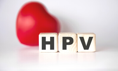 HPV the word on wooden cubes, cubes stand on a reflective white surface, Medicine concept