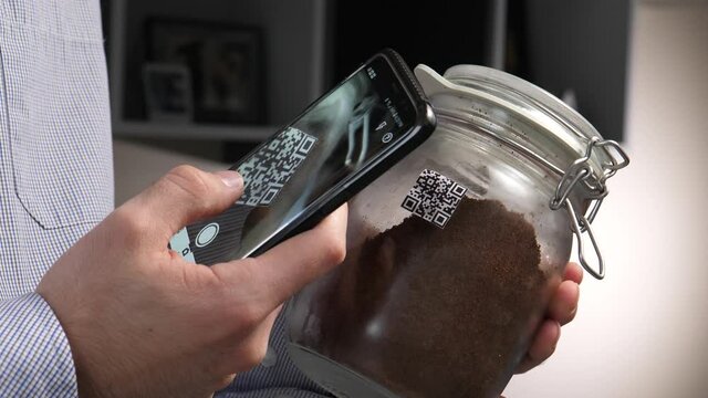 Scanning a QR code on a coffee jar with a mobile phone.