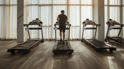 Man running on a treadmill. running on treadmill with sunlight.