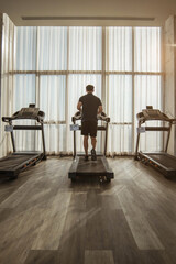 Fototapeta premium Man running on a treadmill. running on treadmill with sunlight.
