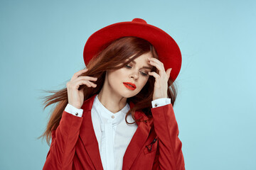Beautiful woman in red hat jacket red lips long hair charm blue background