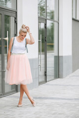 Blonde woman posing on city street