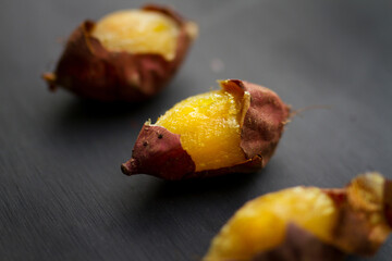 Delicious baked and grill sweet potato put on black wood background.