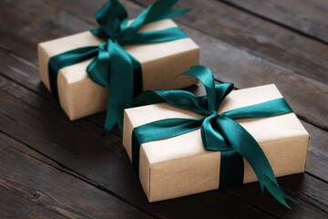 Two gift boxes with bow on dark wooden table with copy space