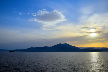 cargo ship travels at sunset