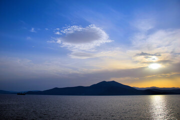 cargo ship travels at sunset