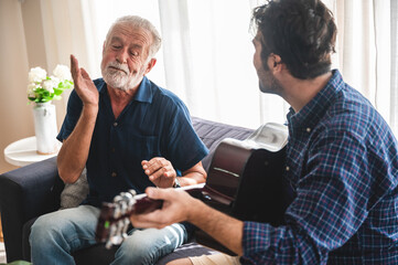 Quarantine time: Happy family son and dad at living room together to play music.