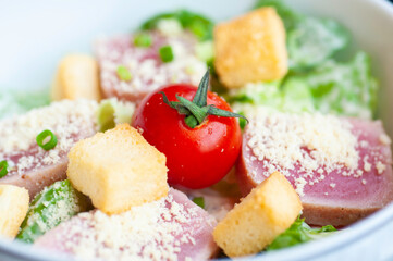 Fresh salmon salad light meal for healthy, Vegetables and red tomato cheese and crispy bread in white bolw.