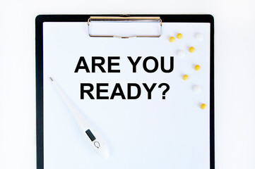 On the tablet for writing the text ARE YOU READY, next to the thermometer and tablets.