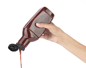 ketchup pouring out of bottle isolated on white background.